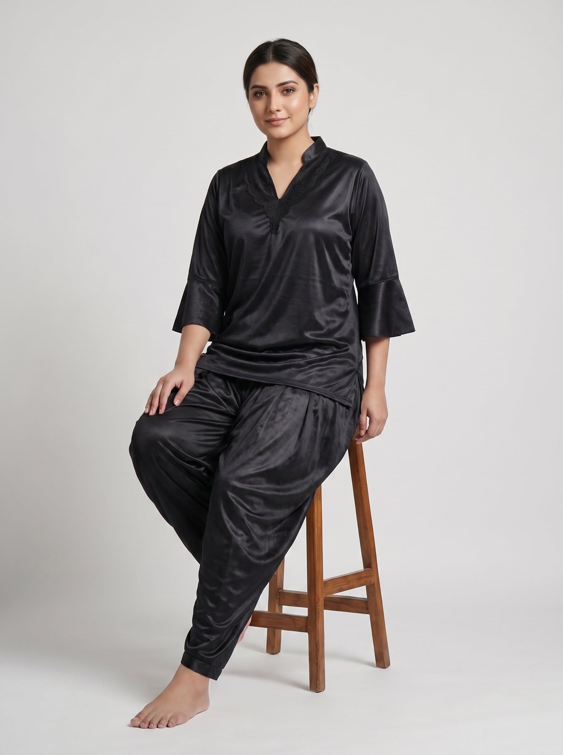 Indulge in effortless elegance with this luxurious black satin night suit, featuring a beautifully detailed lace-trimmed neckline and stylish flared sleeves.