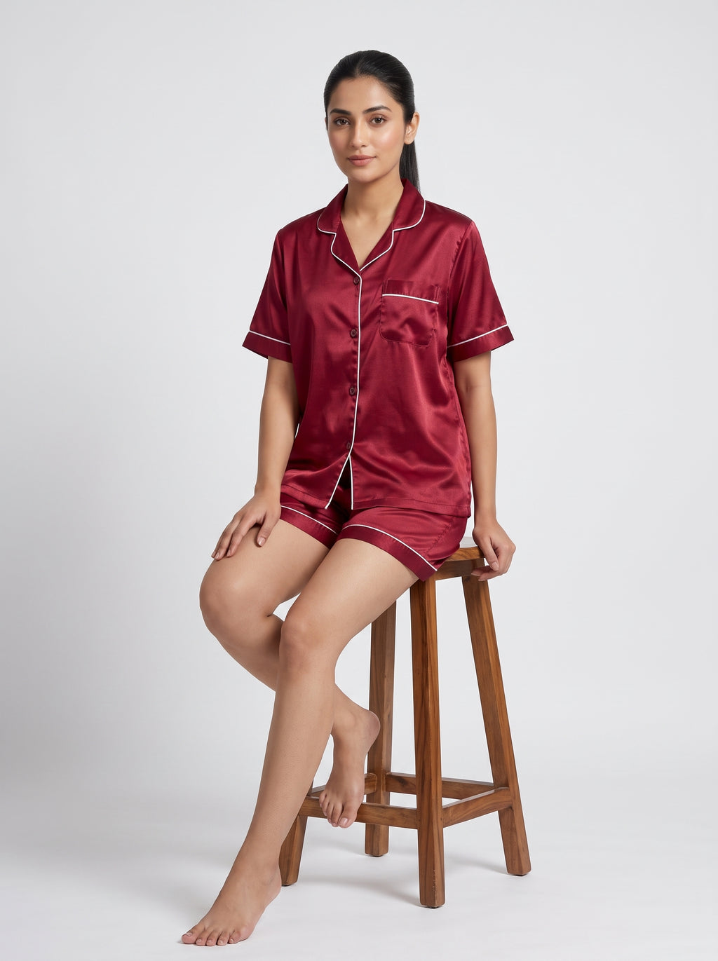 Relax in effortless comfort with this elegant satin pajama set, designed with a classic button-down top and matching shorts