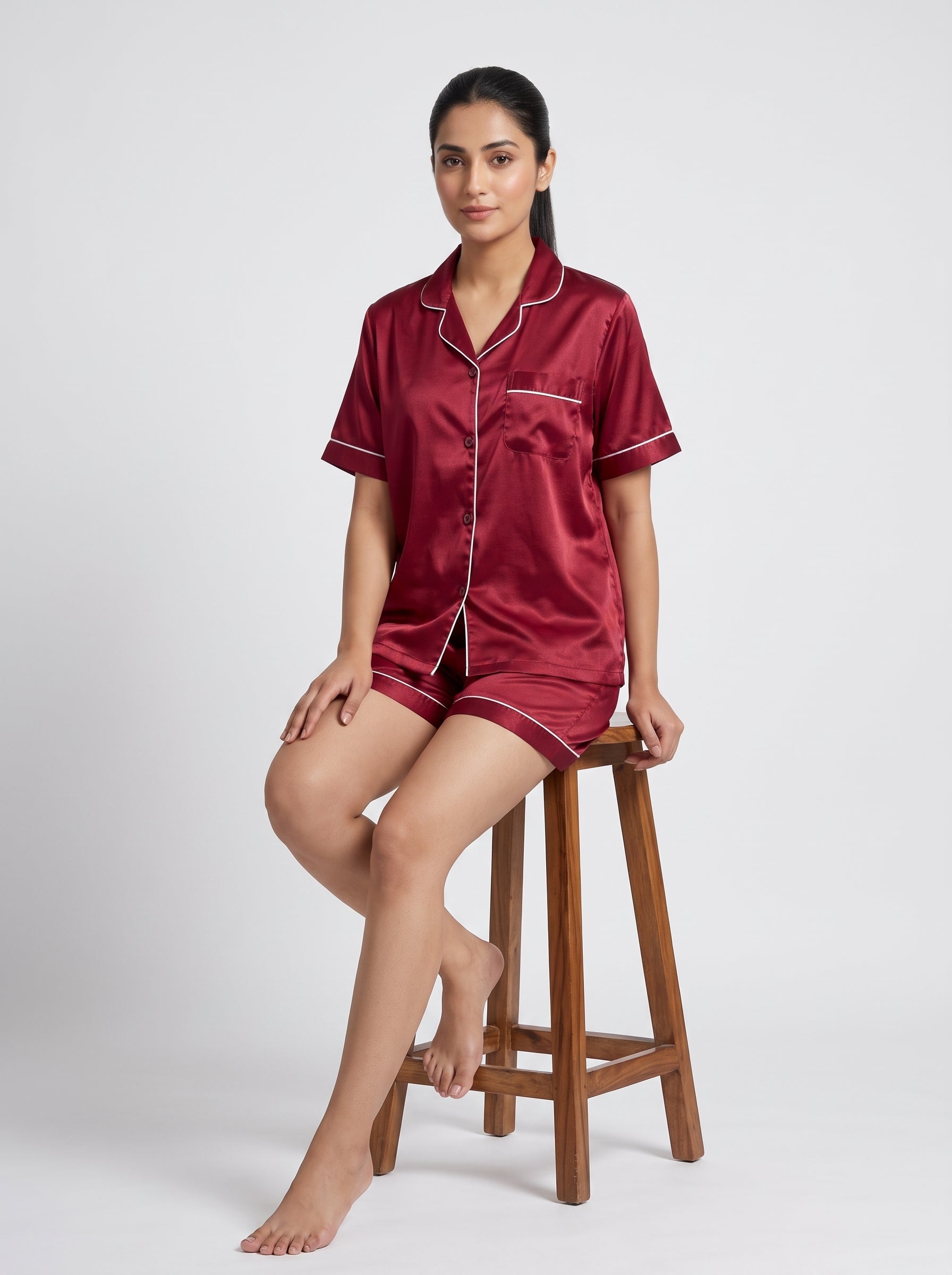 Relax in effortless comfort with this elegant satin pajama set, designed with a classic button-down top and matching shorts